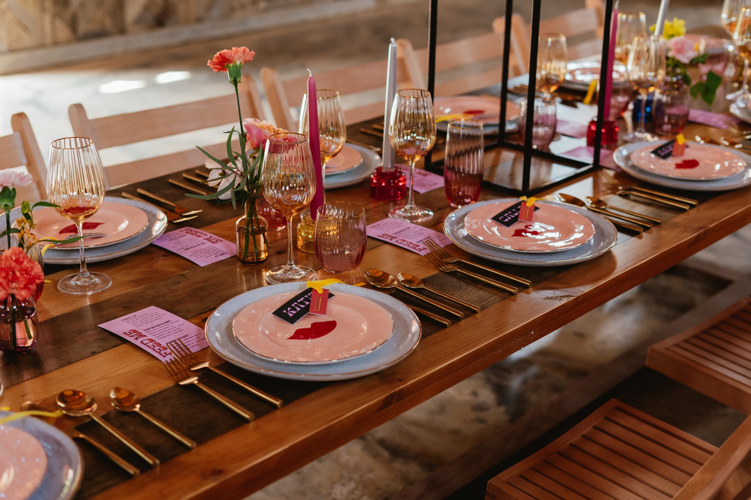 A wedding table at The Canary Shed of colours and alternative decorations: plates, cutlery, glasses, flowers